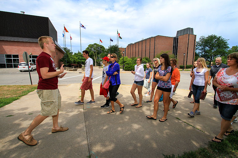 Image of UW-L Senior Ben Urbanek guiding a group past Cowley science Hall.