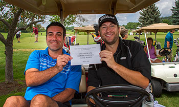Two men in golf cart.