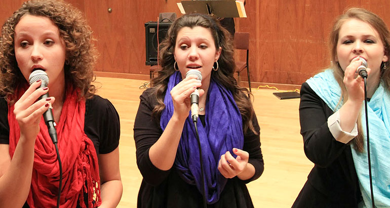 Photo of three women singing.