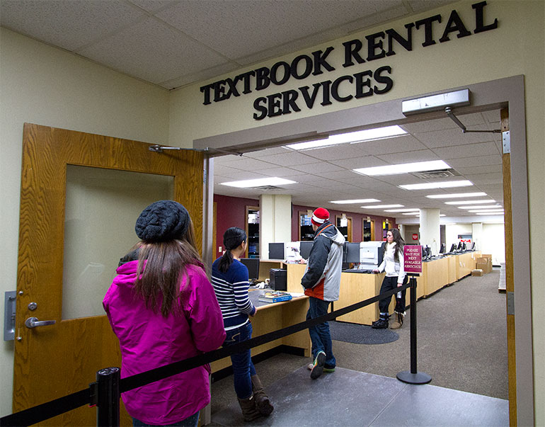 Students in short line at textbook rental services. 