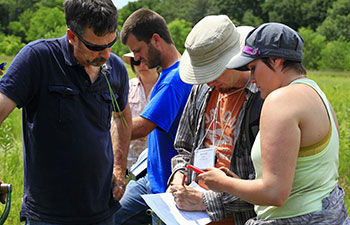 Students looking at data log in wetlands.