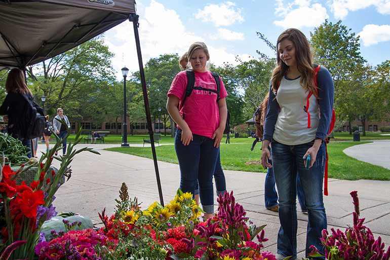 Students looking at flowers in market. 