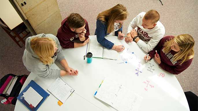 Students gather around a desk studying together at Murphy Library at UW-La Crosse