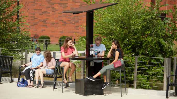 Students charge their phones at a new campus solar-powered station while meeting up with friends.
Read more →
