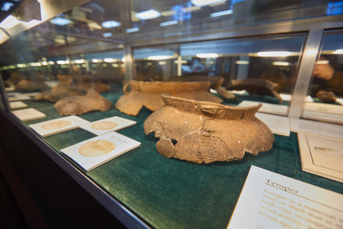 pieces of pottery from the Oneota period in a glass case.