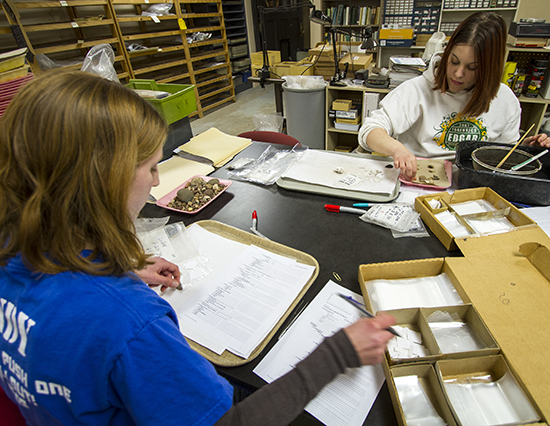 student workers cleaning artifacts