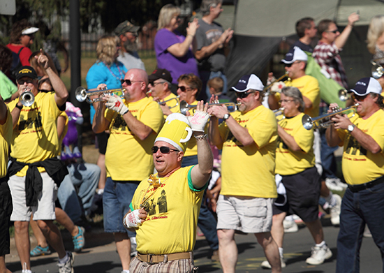 UW-L Alumni Band trumpet players walk and play in parade. 