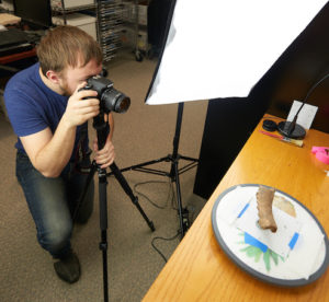William Feltz taking photos of an artifact.