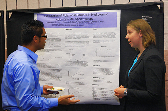 UW-L student Stephanie Sippl talking in front of her research poster. 