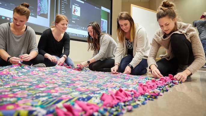 Members of UWL’s Radiation Therapy Club work on one of the blankets to deliver to Gundersen Health System during a club meeting at the end of November. From left are, Morgan Watson, club historian; Lexie Radle, vice president; Erin Richardson, president; Stephanie Hoff, treasurer; and Courtney Kocken, vice president. More than five years ago club member took on the service project to bring more of a career connection to their community service. 
Read more →