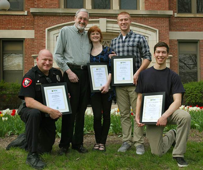 Image of campus heros posing with plaques. 