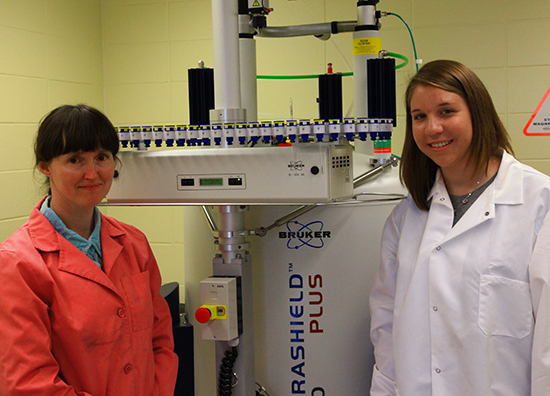 UW-L Assistant Professor of Chemistry Heather Schenck and her undergraduate research student Stefanie Sippl stand by the instrument used to uncover the molecule's structure.