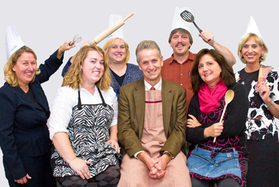 CookieOffGroupCroppedw Group photo of staff with cooking utensils.