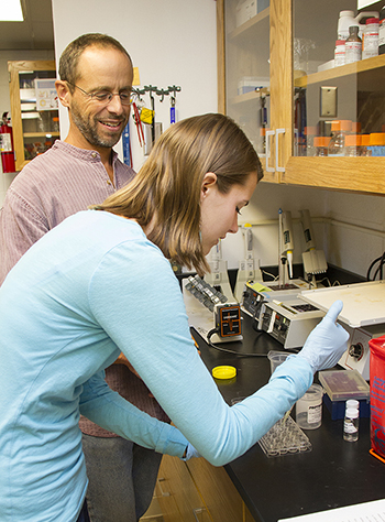 Image of Rachel Schoone working on an experiment as Scott Cooper oversees. 