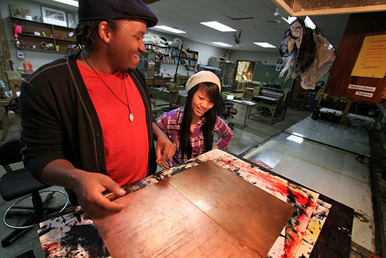 Dewayne Wrencher handling his art work in the art studo. 