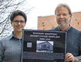 Student and Professor Lee holding photo. 