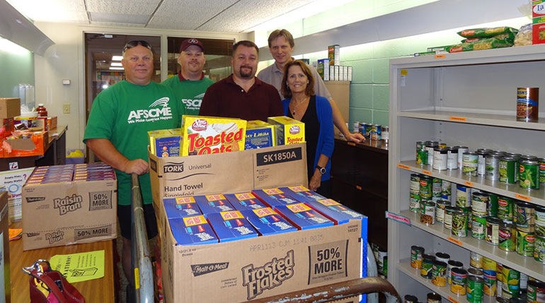 Donations1690w Five people in food pantry with donations of food.