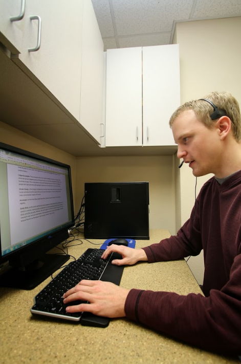 Work study student Aaron Walker types on a computer.