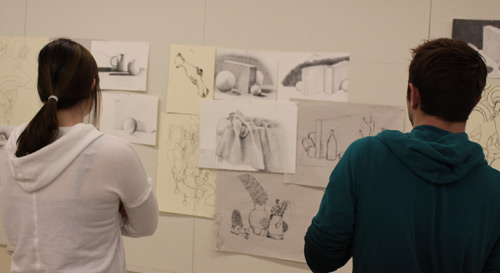 exhibitW Photo of two people looking at artwork.