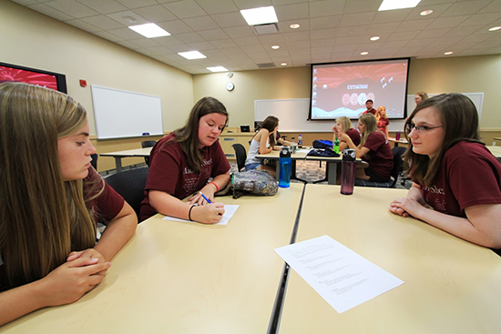 Students writing at a table.