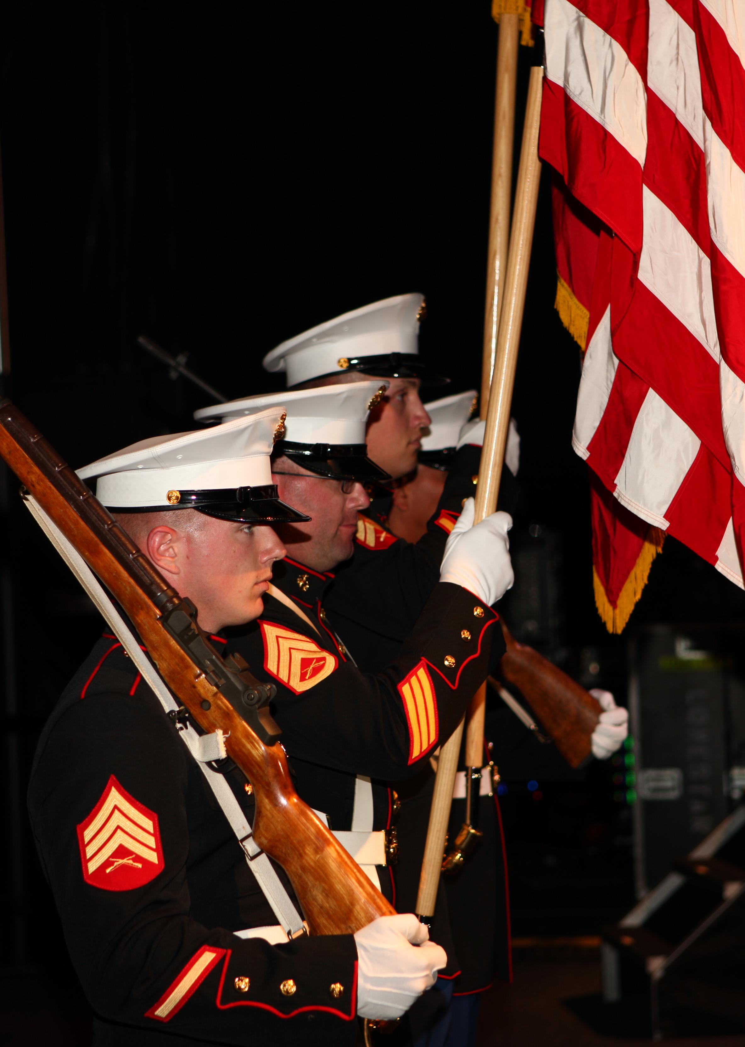 Service members carrying American flags at prior Freedom Fest. 