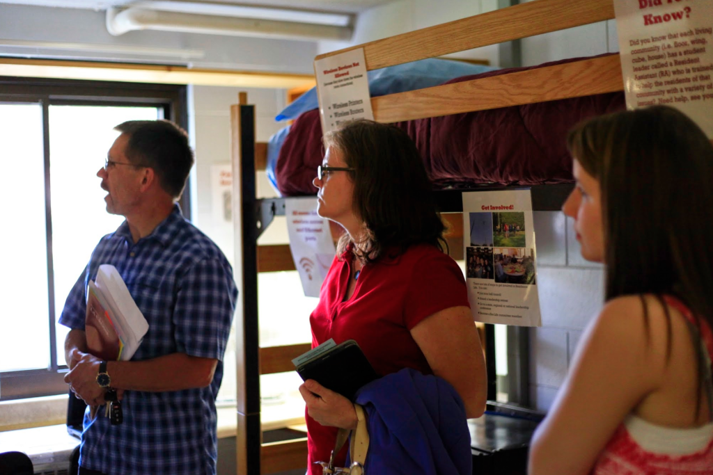 Image of freshman and her parents in a residence hall room.