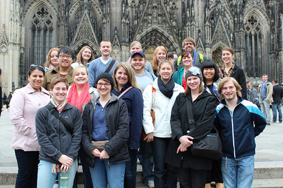 A group of students pose in front of a Cathedral in Germany. 