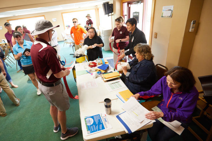 Mary Beth Vahala, associate director of University Centers, and Karmin Van Domelen, ’84, a staff member on the organizing committee, work at the registration table. Many volunteer time and talent to the annual outing. Vahala has  volunteered at the event all 20 years.