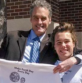 Image of Jow Gow holding a T-shirt with arm around Jonathan Flinchman. 