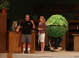 Students rehearse for "Little Shop of Horrors." Two students pictured with large plant.