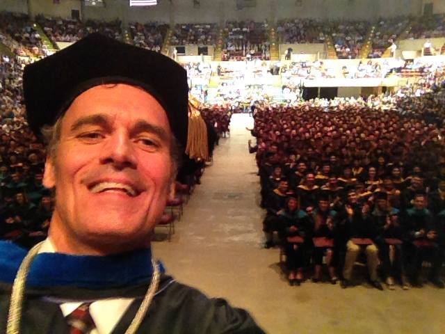 Selfie of Chancellor Joe Gow with graduation ceremony crowd in the background.
