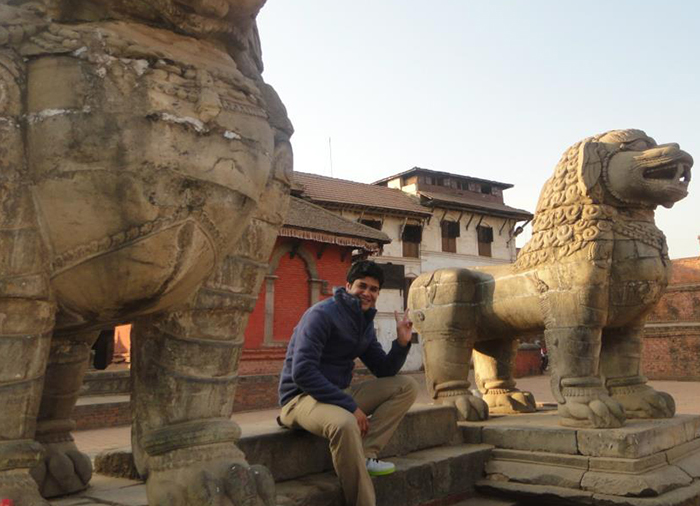 Suresh Kandel sitting in front of a monument. 