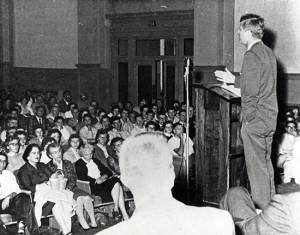 Image of John Kennedy speaking in Graff Main Hall auditorium.