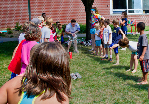 Kids playing with water balloons at camp.