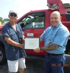 Two men shaking hands holding certificate.