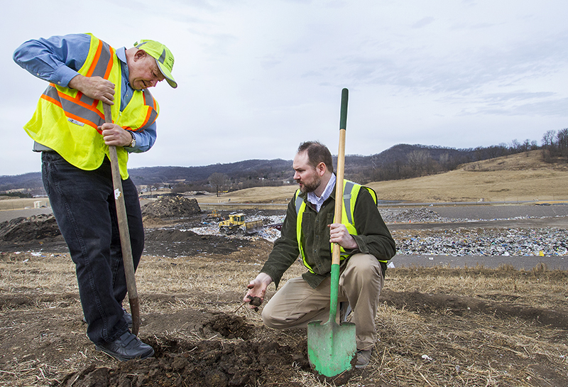 Hank Koch and Paul Reyerson with shovels digging into dirt at the landfill. 