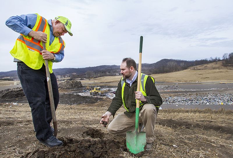 Hank Koch and Paul Reyerson with shovels digging into dirt at the landfill.