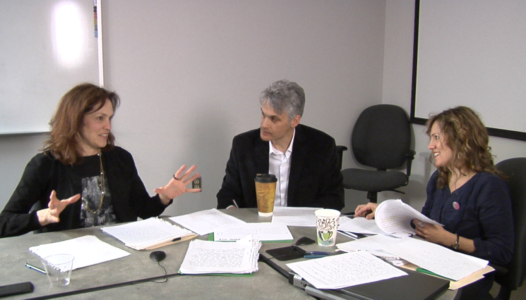 Image of Susan Crutchfield, Bryan Kopp and Kelly Sultzbach sitting around a table with papers discussing.