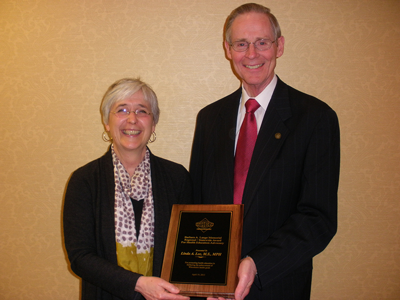 Gary Gilmore, chair of Wisconsin Health Education Network and UW-L professor of Health Education & Health Promotion, presents the Barbara A. Lange Memorial Award to Linda Lee, nutrition manager for the La Crosse County Health Department.