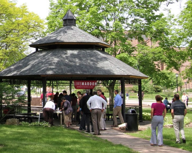 Image of gazebo with people gathering around.