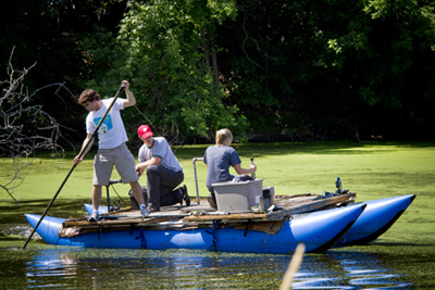 From left, Jake Roberts, Colin Belby and Sara Erickson. Jake Roberts, UW-L senior, Colin Belby, UW-L assistant professor of geography and Sara Erickson, UW-L senior, move a raft through the marsh to collect soil samples.