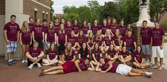 Students pose for photo outside Centennial Hall. 