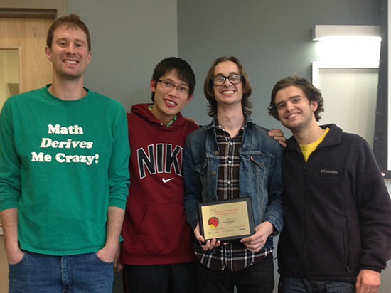 Students standing holding an award plaque. 