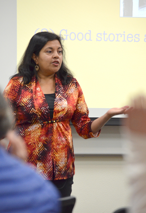 Image of Mitali Perkins speaking to a group in front of a screen with the words "Good Stories."