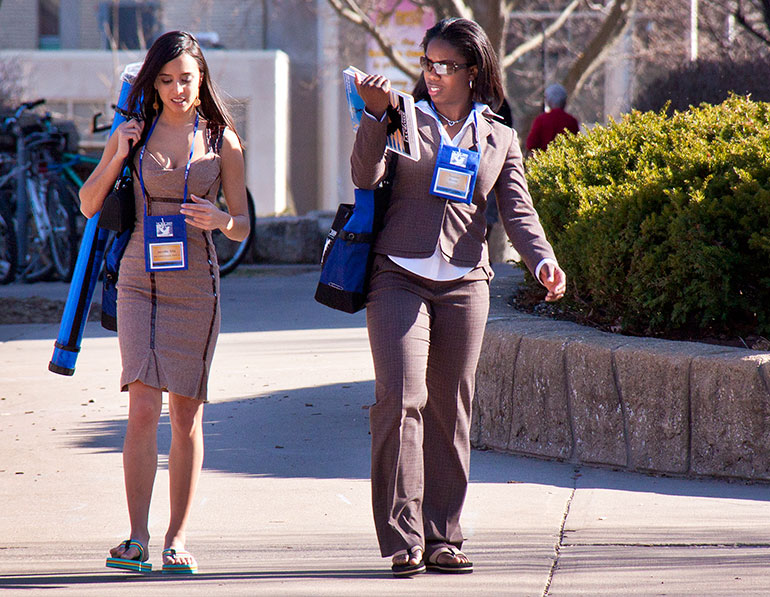Two students with blue NCUR tags. 