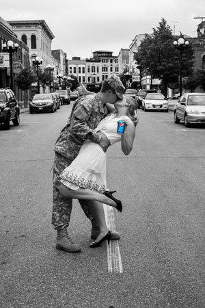 Photo of soldier kissing woman in street.