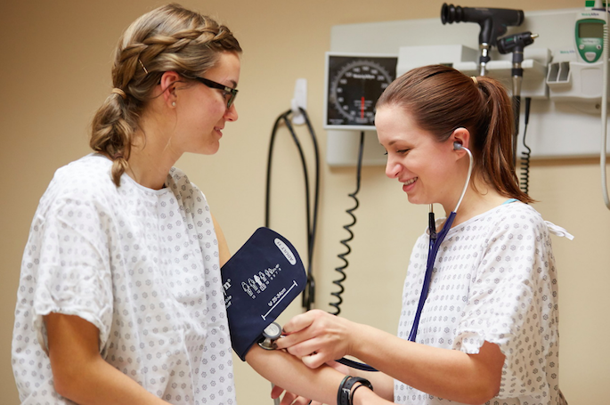 Students practice checking blood pressure during a class. 