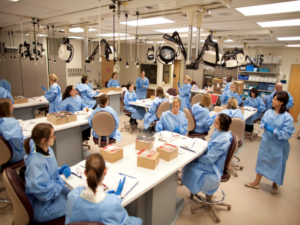UW-L physician assistant students in a clinical procedures course are pictured in lab coats working. 