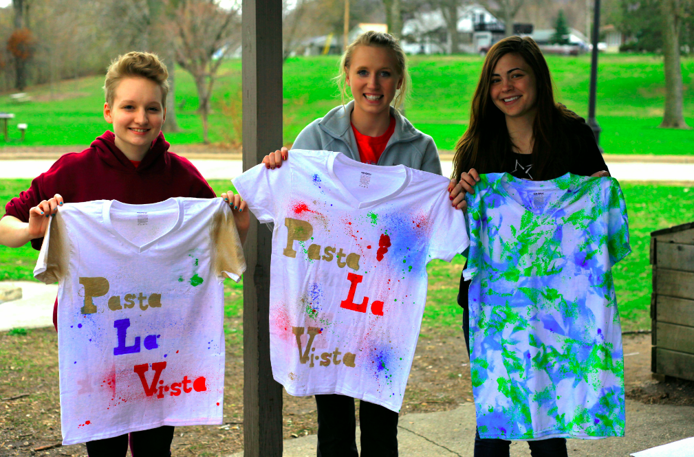 Three students stand with teachers at Pasta La Vista event.