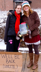 Two students holding donation can. 